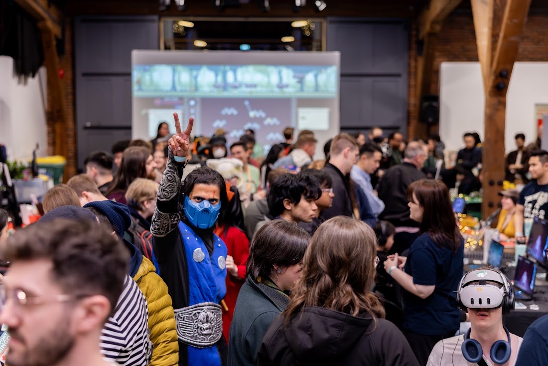 A busy expo floor with a cosplayer flashing a peace sign