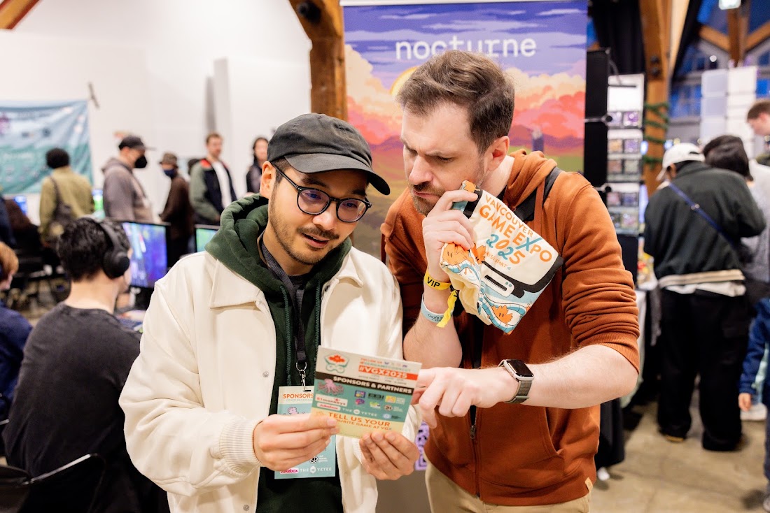 Two attendees studying the sponsors pamphlet