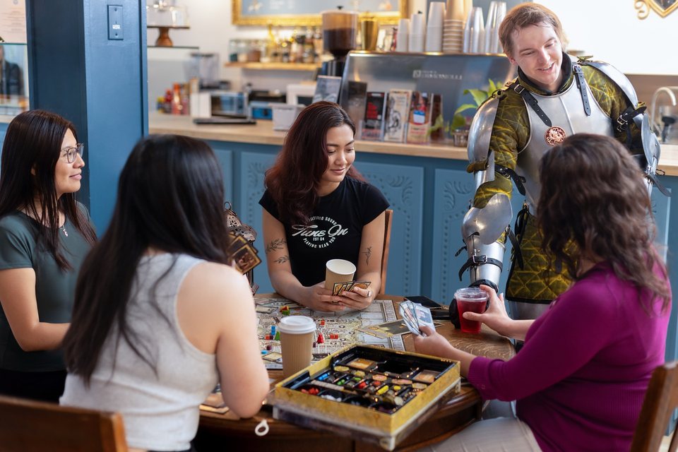 Friends playing a board game at the Academie Duello cafe